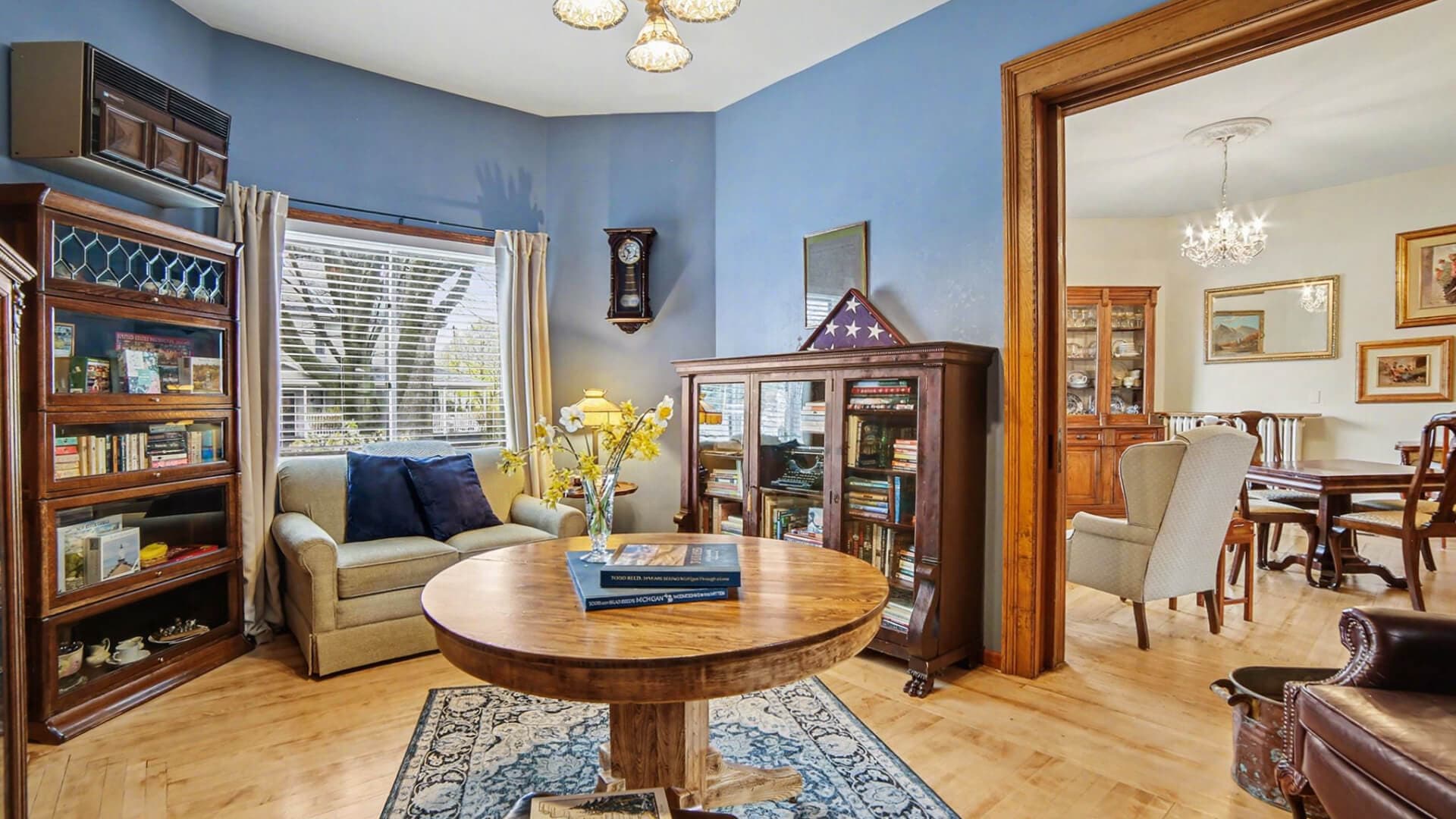 Cozy living room featuring a round table, bookshelves, and elegant decor in a warm color scheme.